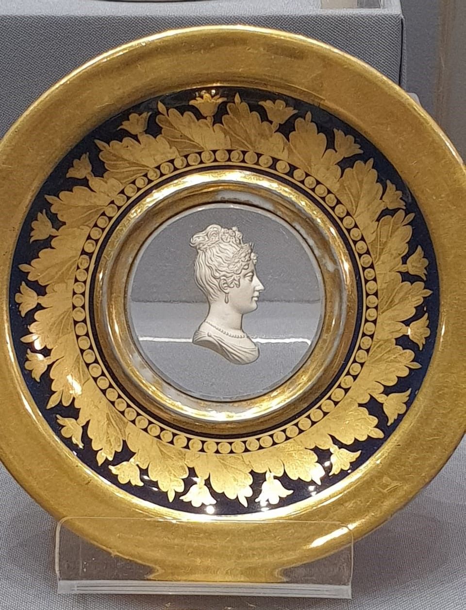 Блюдцем с портретом Евгении Дезире Клер. Мастерская Депре. 1810-е гг. Фарфор, подглазурная и надглазурная роспись, позолота, цировка; дно - стекло, кристалло-керамика